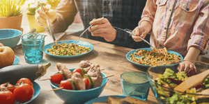 two people eating prepared food