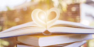 an open book with a heart shape made out of the inner page