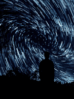 a man starring at a time-lapse night sky