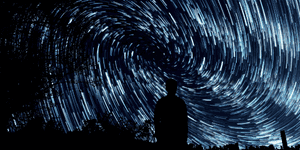 a man starring at a time-lapse night sky